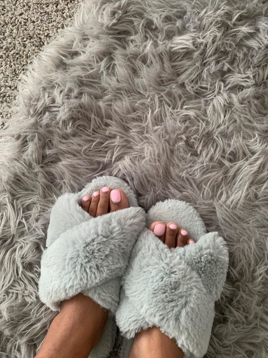 A reviewer wearing the grey version of the slippers.