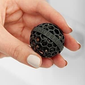 A person holding a black ball in their hand