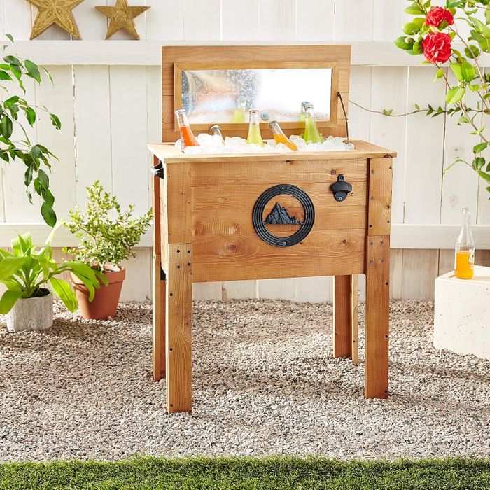 A portable wooden outdoor bar station with a storage shelf and metal towel holder