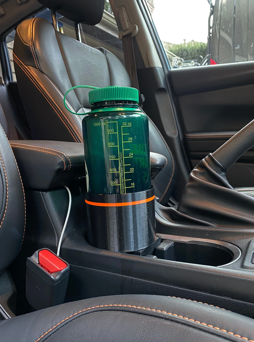 A large green water bottle with measurement markings sitting comfortably in a car's cup holder