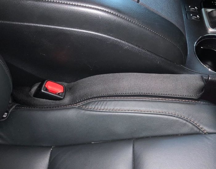 A reviewer's photo of a car with the DropStop seat gap filler installed on the left side of the passenger seat