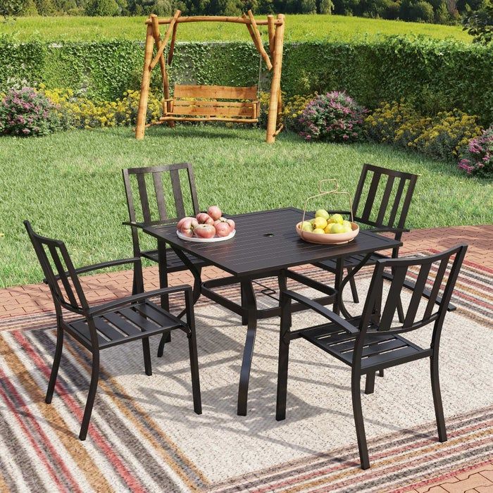A stylish outdoor patio set complete with a table and four chairs, all set on a cozy rug.