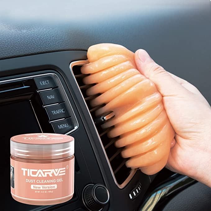 A model cleaning a car vent with the putty
