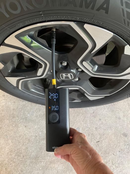 reviewer using their tire inflator on their tire