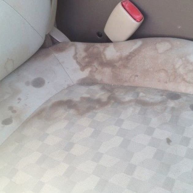 A reviewer photo showing a stained seat before using the spot remover