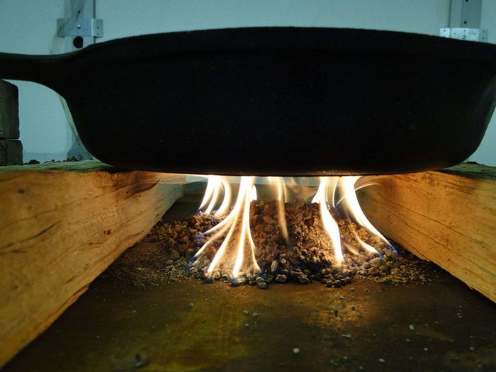 A cast iron skillet sizzling over an open outdoor flame
