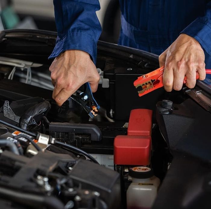 model using the jumper cables to jumpstart a car