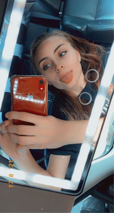 A reviewer using their LED mirror to take a mirror selfie