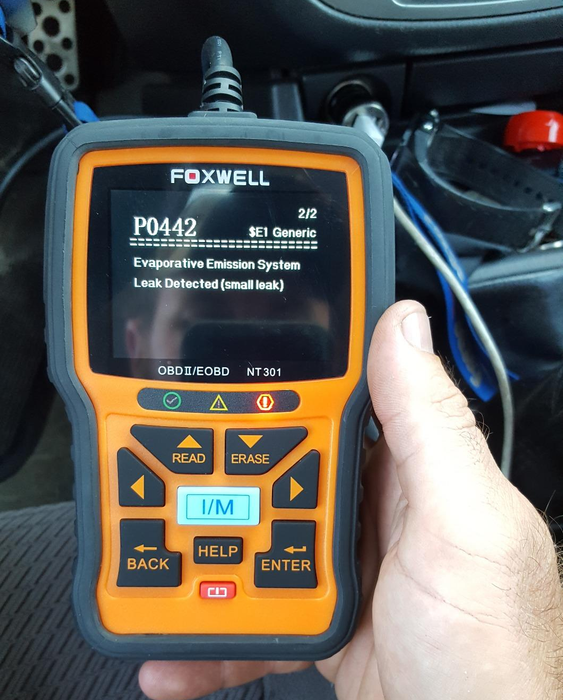 reviewer holding their orange diagnostic code reader