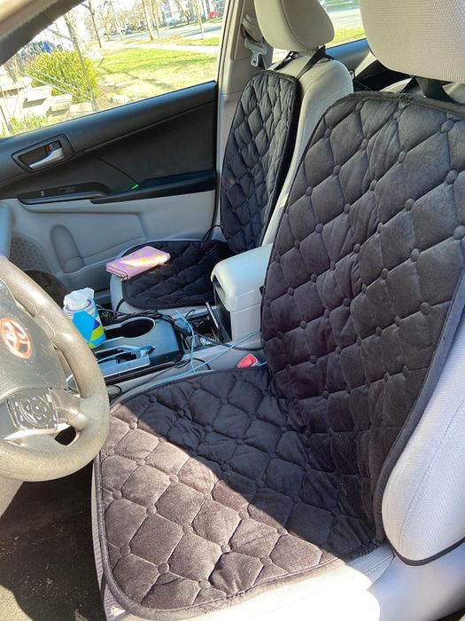The heated car seat pads in use in a reviewer's car