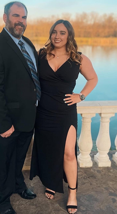 Image of a reviewer in a black dress standing next to another person.