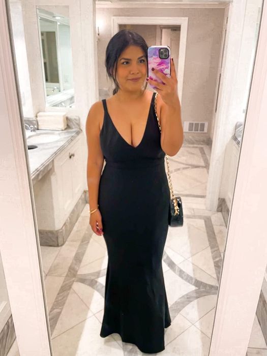 Reviewer wearing the dress in front of a mirror in a white and gray bathroom setting.