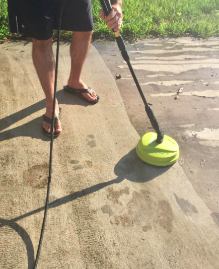 The same reviewer showcases a clean driveway side next to the grimy one, showing the difference after using the electric pressure washer