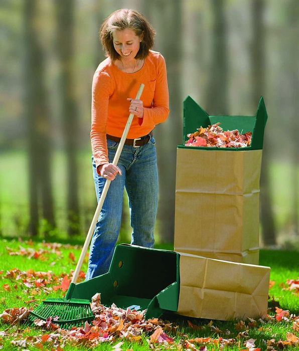 a person raking leaves next to a brown paper waste bag held open with the leaf chute