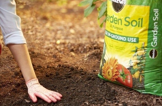 a bag of garden soil placed in a garden setting