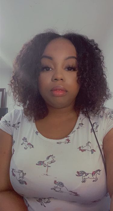 A selfie of a reviewer showcasing their moisturized, healthy curls