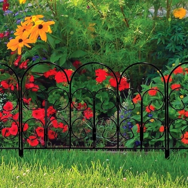 A dark-colored fence installed in a garden setting