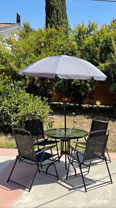 A table set complete with four chairs and an umbrella