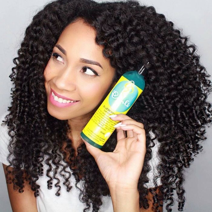 A model with curly hair is pictured holding the curl control jelly.