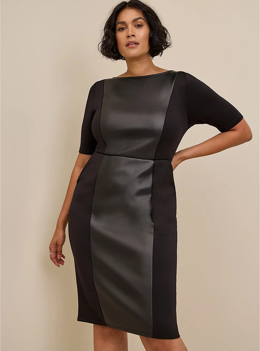 A model is wearing a knee-length black dress made from scuba fabric, featuring three-quarter sleeves and a boat neckline, set against a brown background.