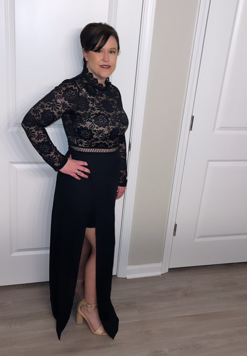 Reviewer wearing the dress with a nude slip underneath and open-toed nude heels, standing in front of a white door.