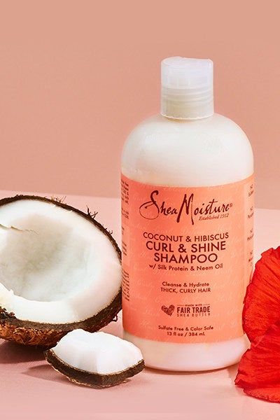 Lifestyle photo featuring the shampoo alongside coconut and hibiscus