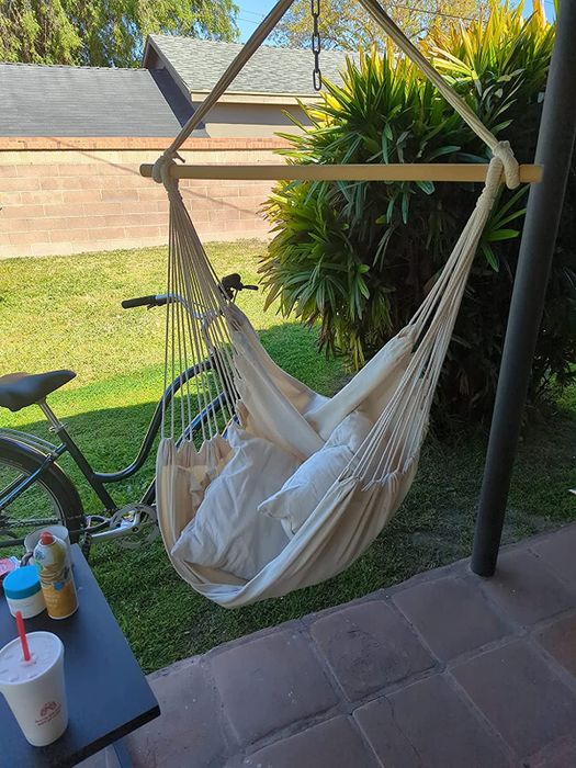 A reviewer image of the hammock chair hanging on a patio