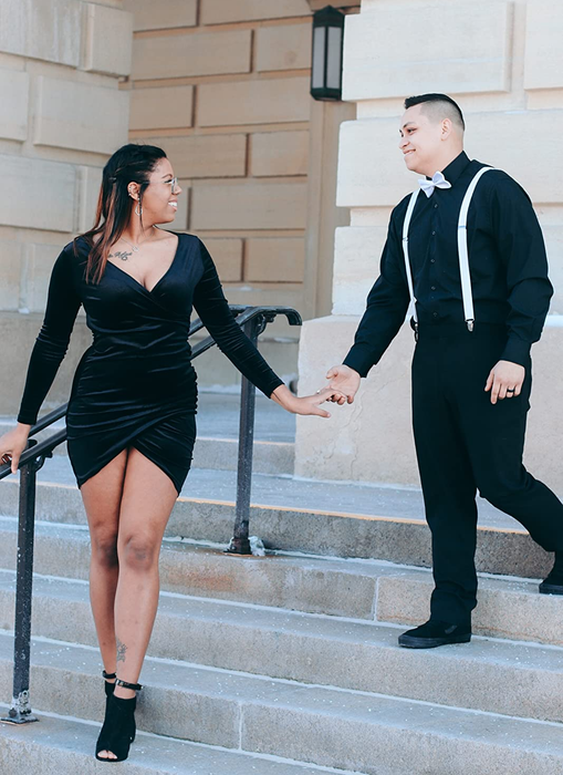 A reviewer styled in the product, wearing black ankle heels on white stairs outdoors.