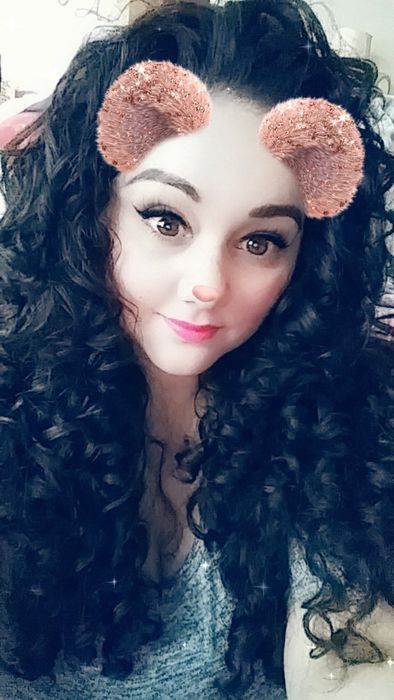 Reviewer's Snapchat selfie with a bear filter, showcasing long black curly hair