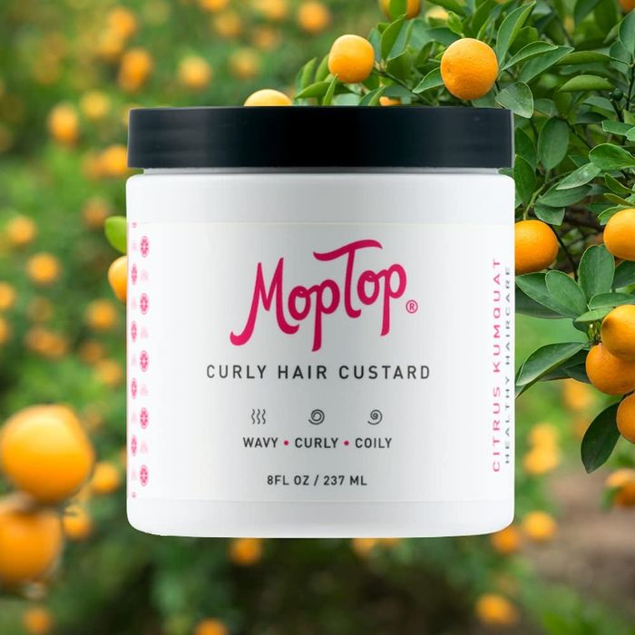 An image of the Curly Hair Custard product set against a backdrop of vibrant orange trees