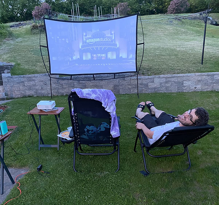 A reviewer's outdoor movie screen set up in a backyard