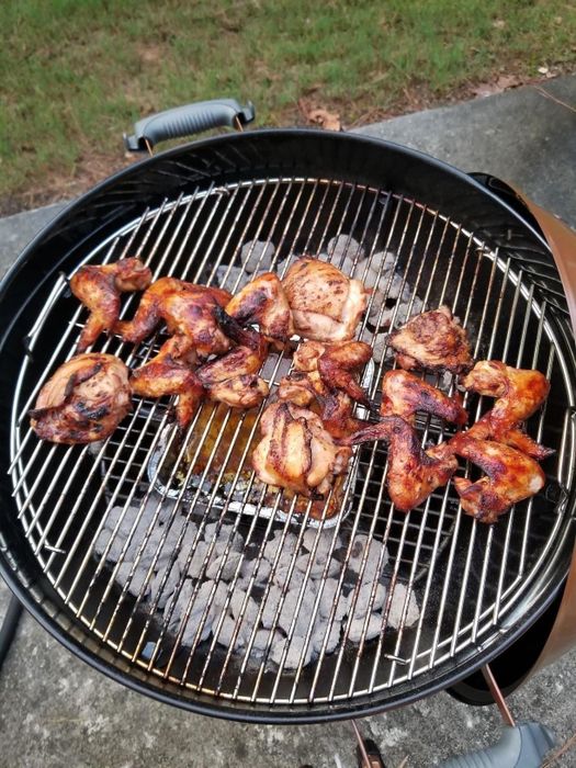 Chicken wings sizzling over charcoal on the reviewer’s Weber grill, cooking to perfection.