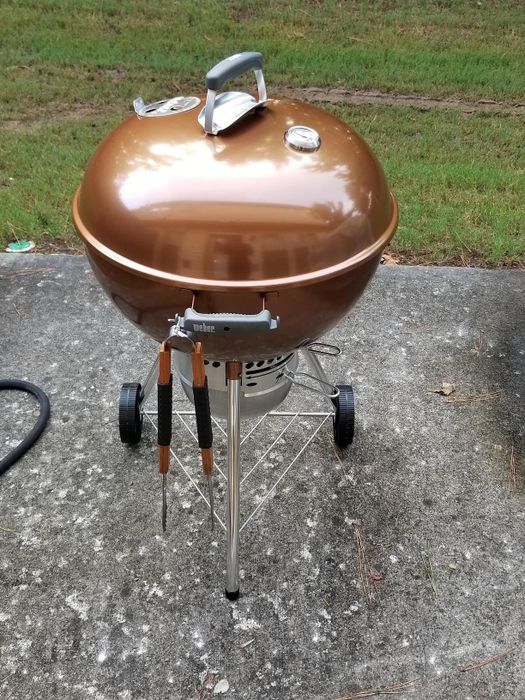 The reviewer's golden Weber charcoal grill, gleaming in the sunlight.