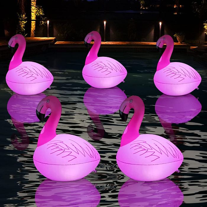 The same floating flamingo-shaped lights now lighting up the pool at night.