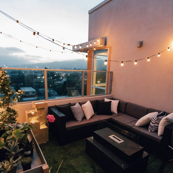 A patio bathed in twilight with round string lights strung along a black wire