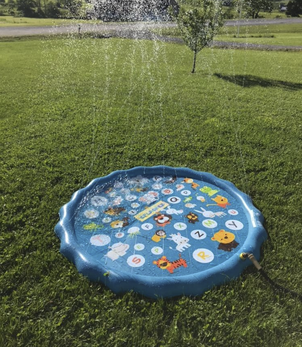 A reviewer’s small inflatable pool, with water spraying from the squirters around the rim, sitting in a yard and connected to a hose.
