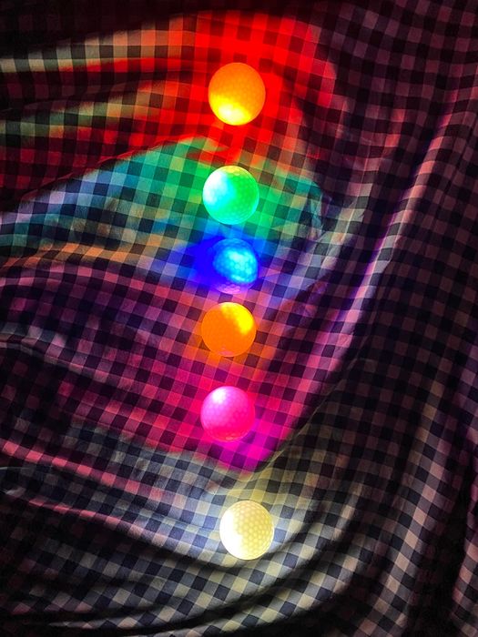 A reviewer's LED golf balls neatly arranged in a row