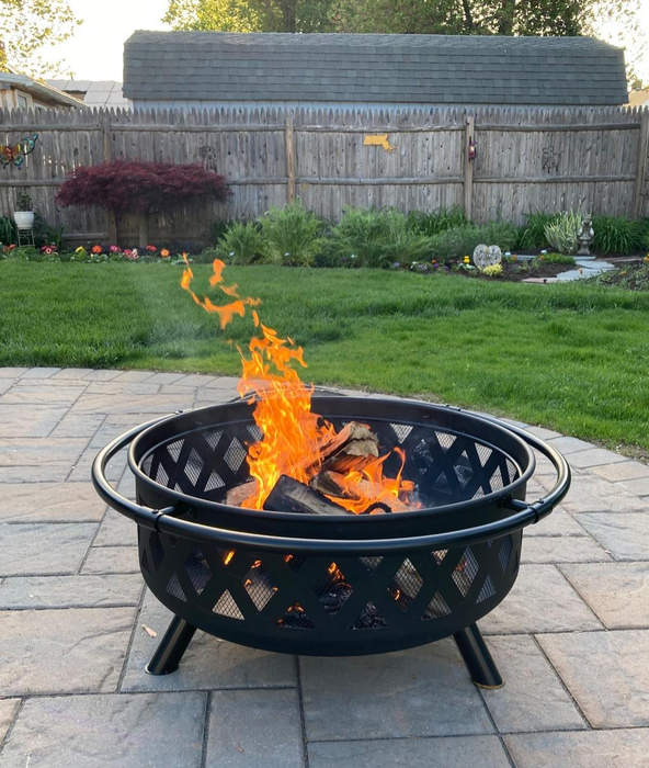 A photo of a glowing fire pit on a patio in the daylight