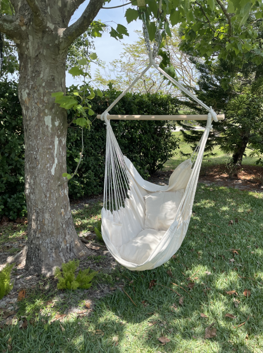 A white hanging hammock chair set up in a reviewer’s backyard, adding to the outdoor relaxation experience.