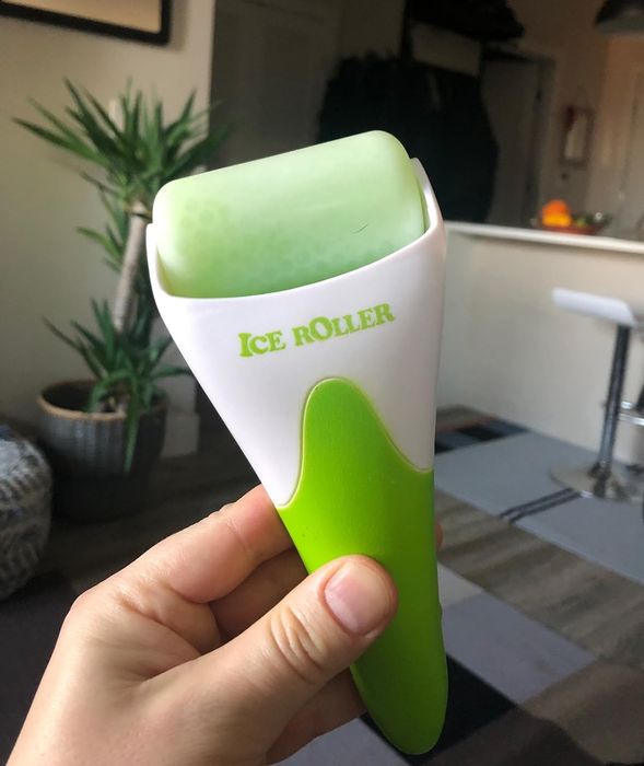A reviewer holding the green ice roller.
