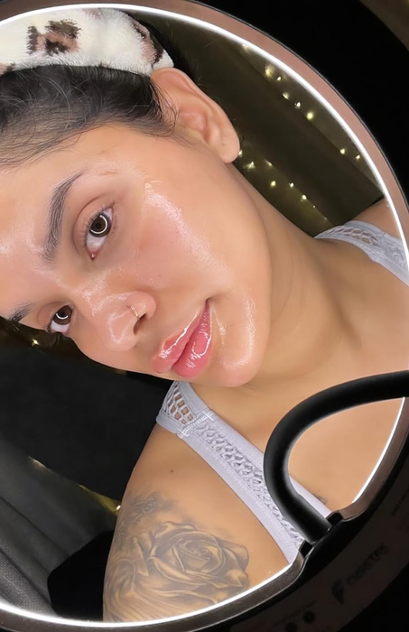 A reviewer showcasing their radiant skin after applying the cleansing oil.