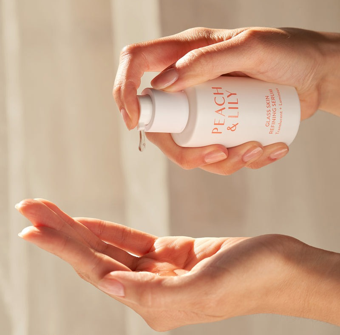 Model applying the Peach & Lily skin serum from the bottle.