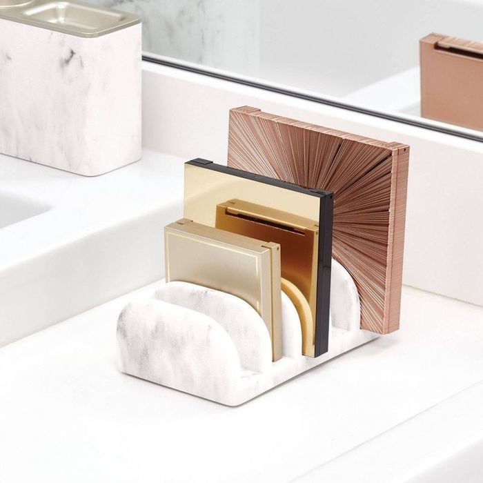 A white and gray marble eyeshadow palette organizer with makeup palettes neatly stored in its designated slots.