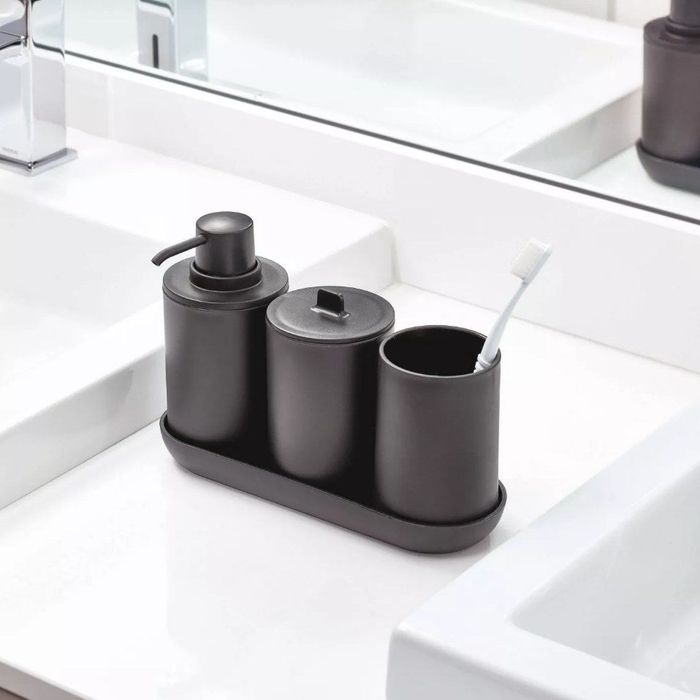 A sleek black four-piece set, including a soap dispenser, a lid canister, and a toothbrush holder.