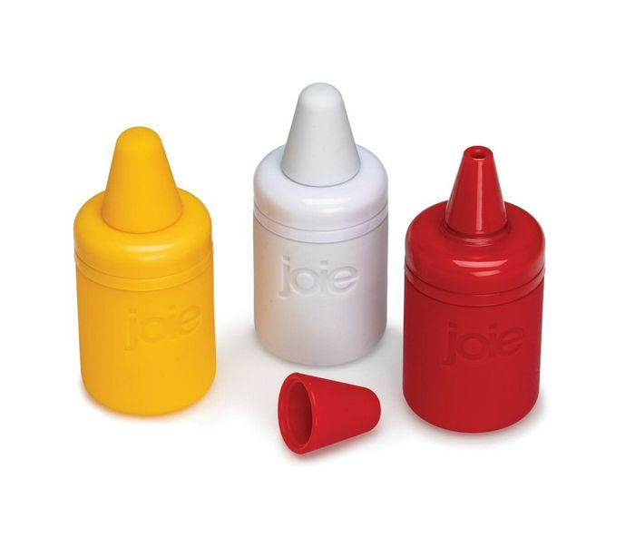 Three Joie squeeze bottles with cone-shaped tips in yellow, white, and red; the red bottle is shown with its cap removed