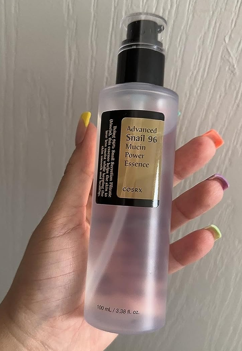 reviewer showcasing the bottle of essence