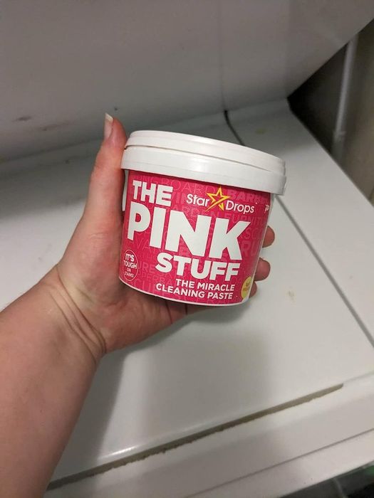 Reviewer holding the tub of The Pink Stuff