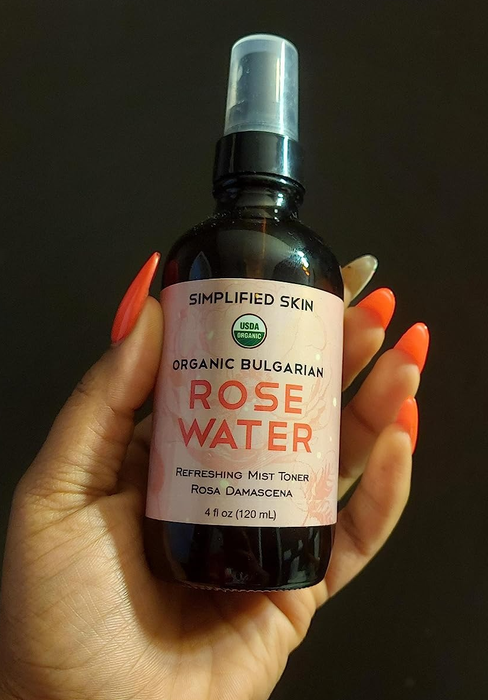 Reviewer holding a bottle of rose water