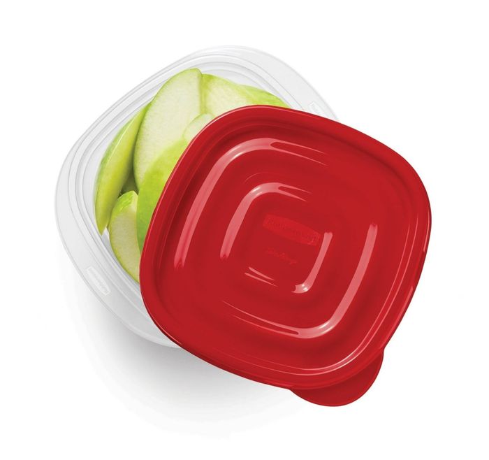 A clear plastic container with a red lid, filled with slices of green apple.