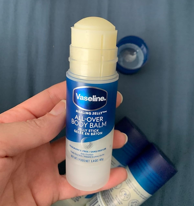 The reviewer is seen holding the body balm stick